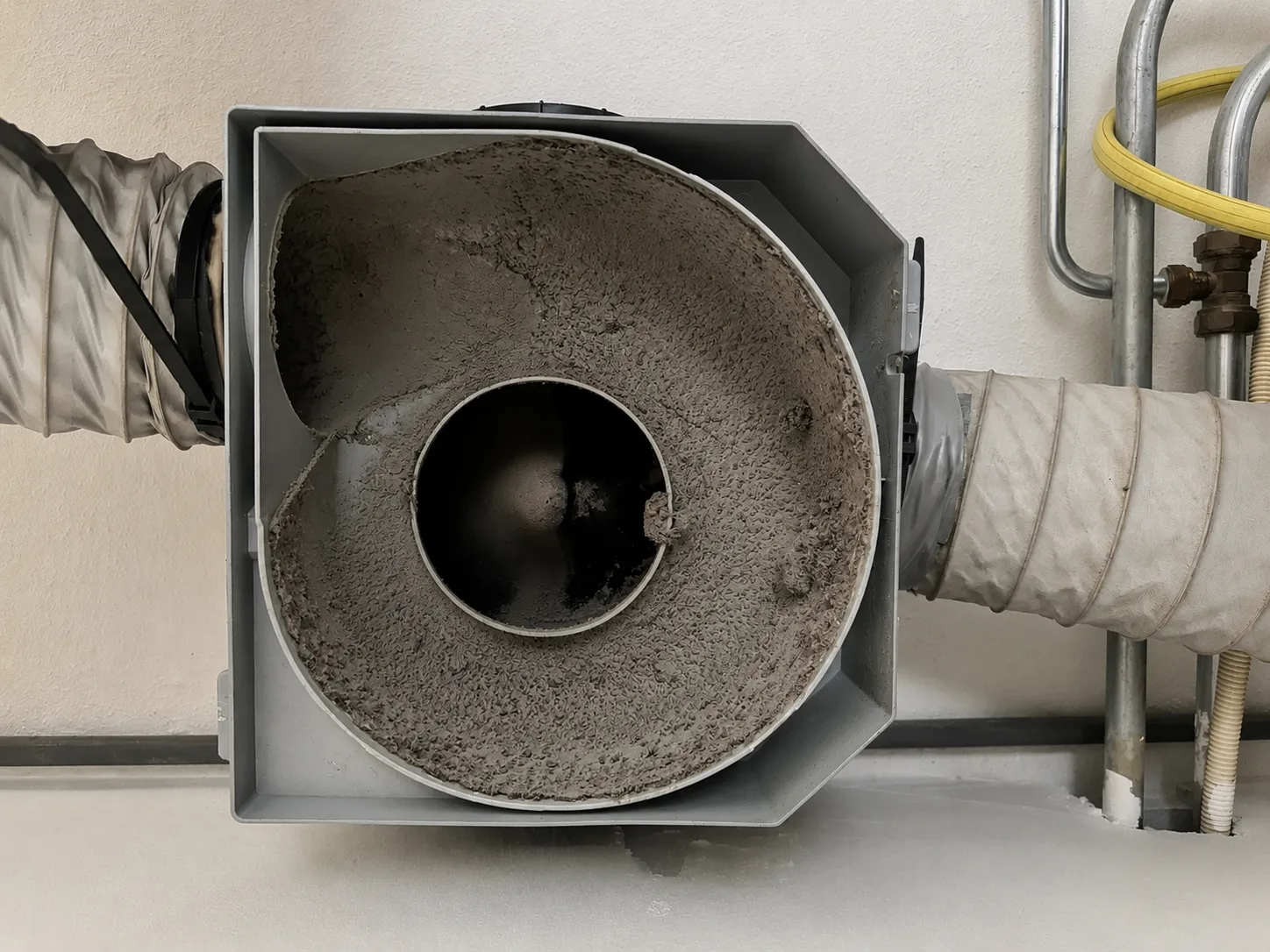 De ventilatiebox met stof en vuil vóór de reiniging